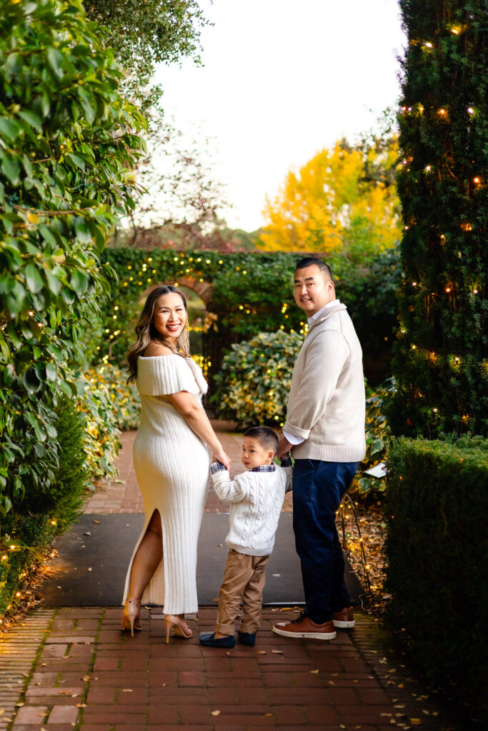 Family walking through the twinkle lit garden path during Filoli Christmas photography session