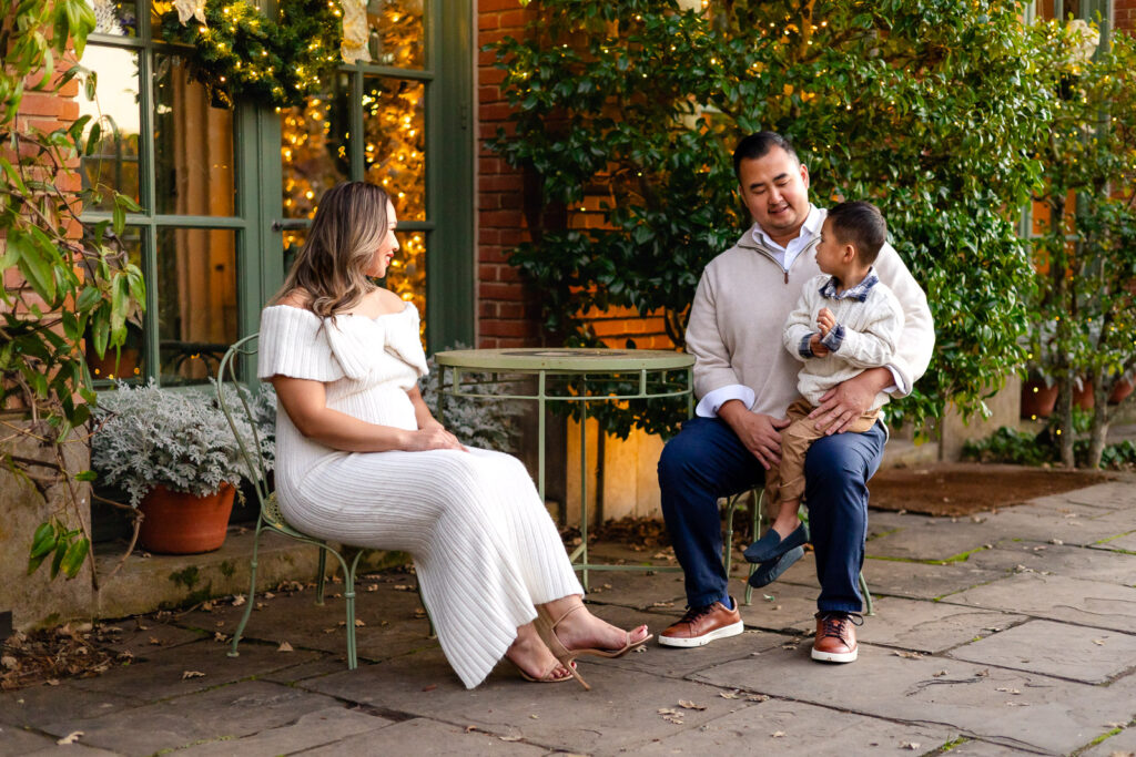 Family sitting together near the Filoli greenhouse during Christmas time photos at Filoli