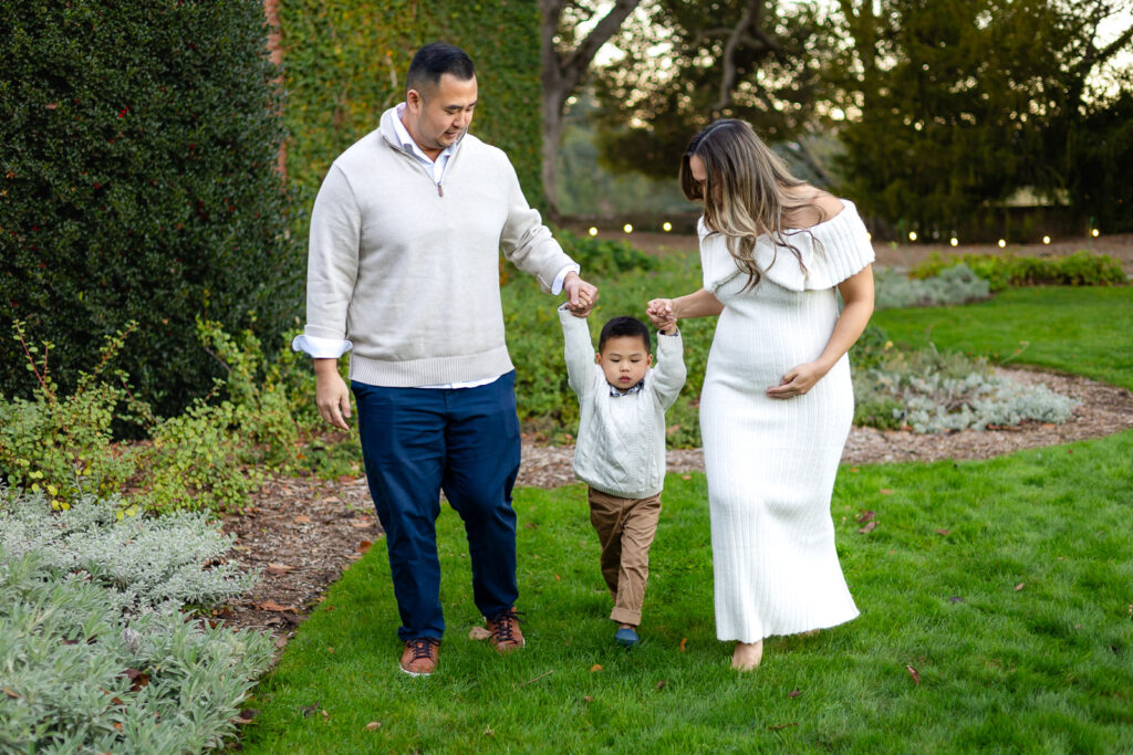 Parents walking with young child on the garden path at Filoli Estate for festive photos