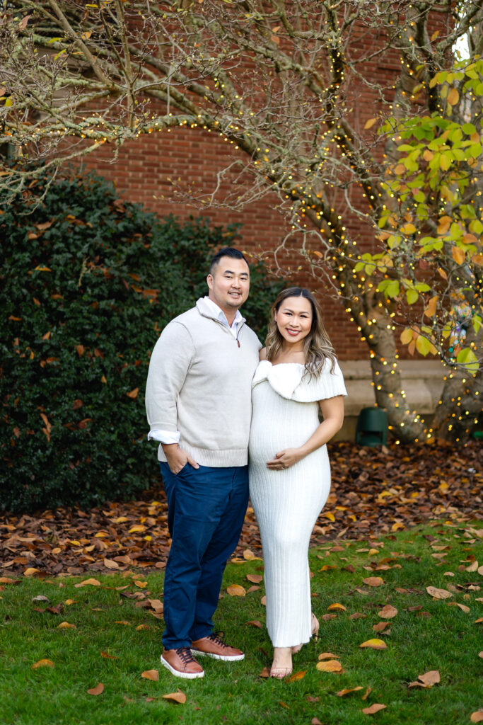 Couple portrait under twinkle lights and fall leaves during family Christmas photos at Filoli