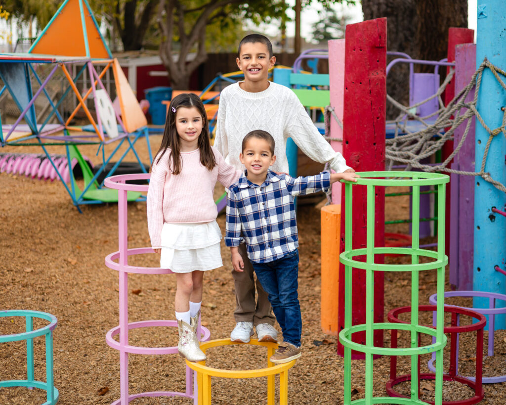 Children posing together on bright climbing structures at Millbrae Nursery School outdoor play area Ellobelle Photography