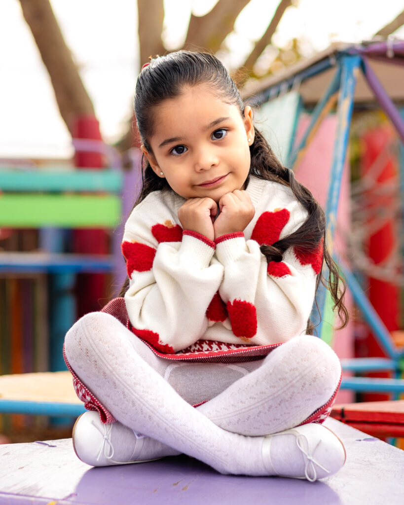 Child sitting cross legged on the purple play structure at Millbrae Nursery School during picture day Ellobelle Photography