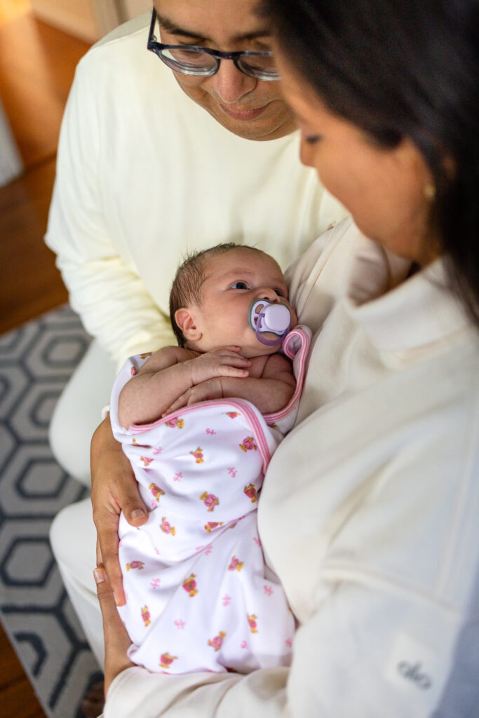 Parents holding their newborn close during a quiet in home San Mateo session inspired by Bay Area help for expecting parents