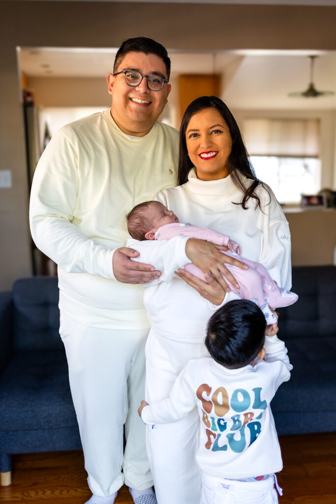 Family standing together at home in San Mateo during a newborn session inspired by postpartum resources in San Mateo County