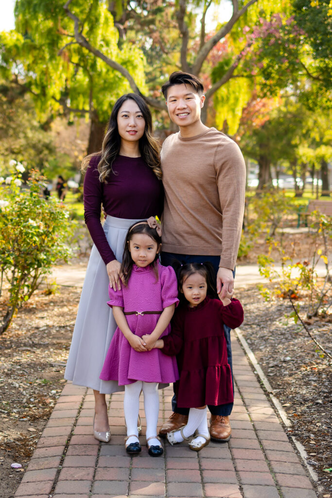 Family standing together in a park garden with fall colors
