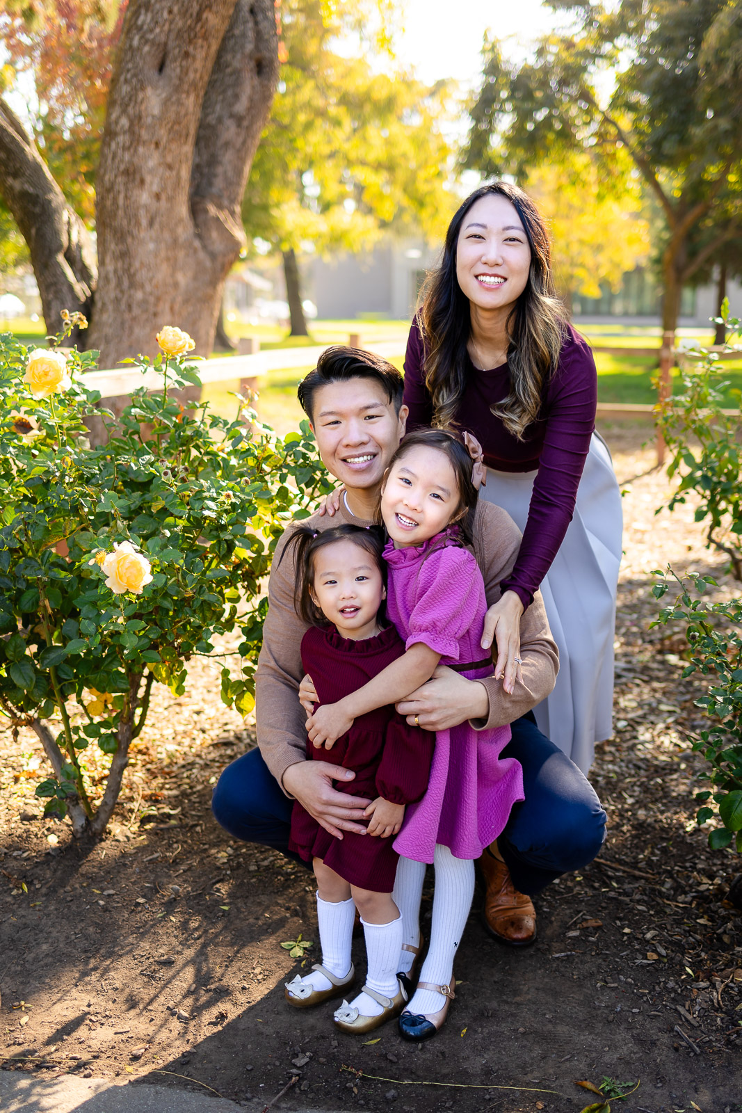 Family hugging by yellow rose bushes during a Burlingame garden session for Family Photoshoot Tips – Ellobelle Photography