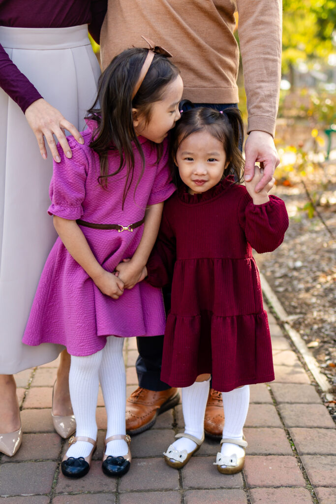 Sisters hugging in a garden setting