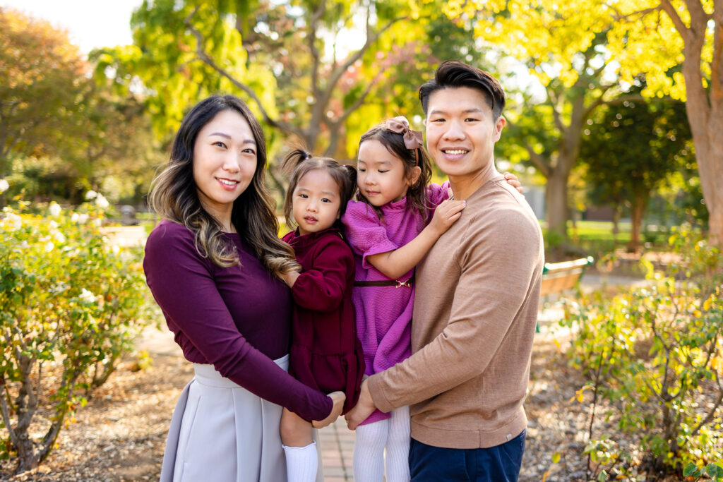 Family holding their daughters during golden hour in a park for a Family Photoshoot