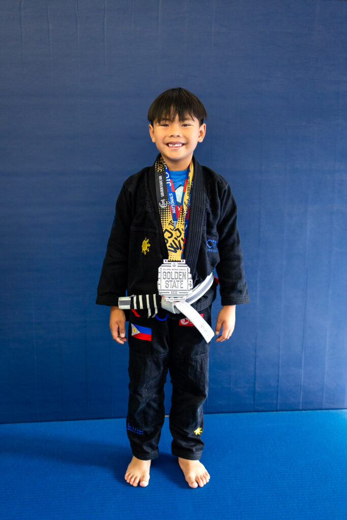 Young athlete from jiu jitsu training for kids wearing medals