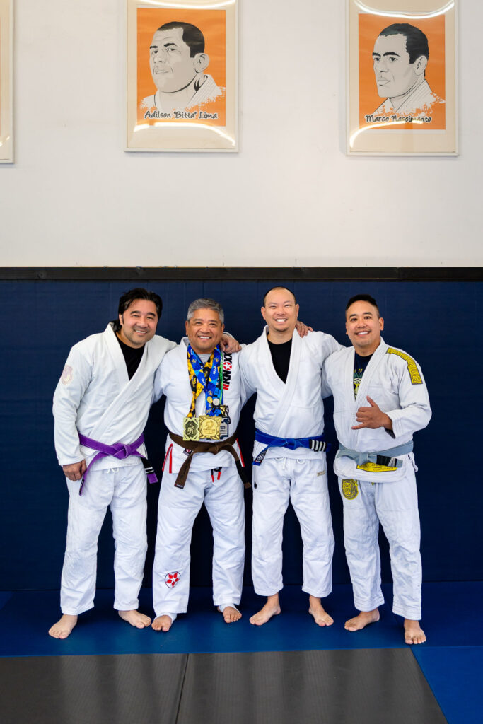 Adult practitioners wearing medals at beginner jiu jitsu session at a local academy
