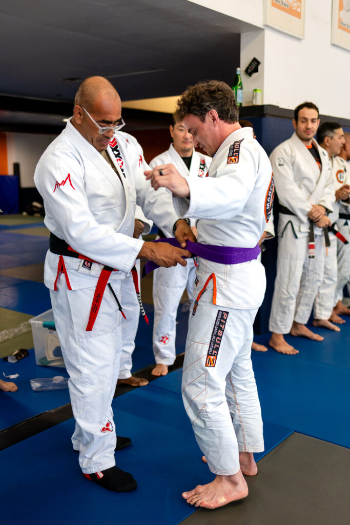 Marco Nascimento awarding a purple belt to a student