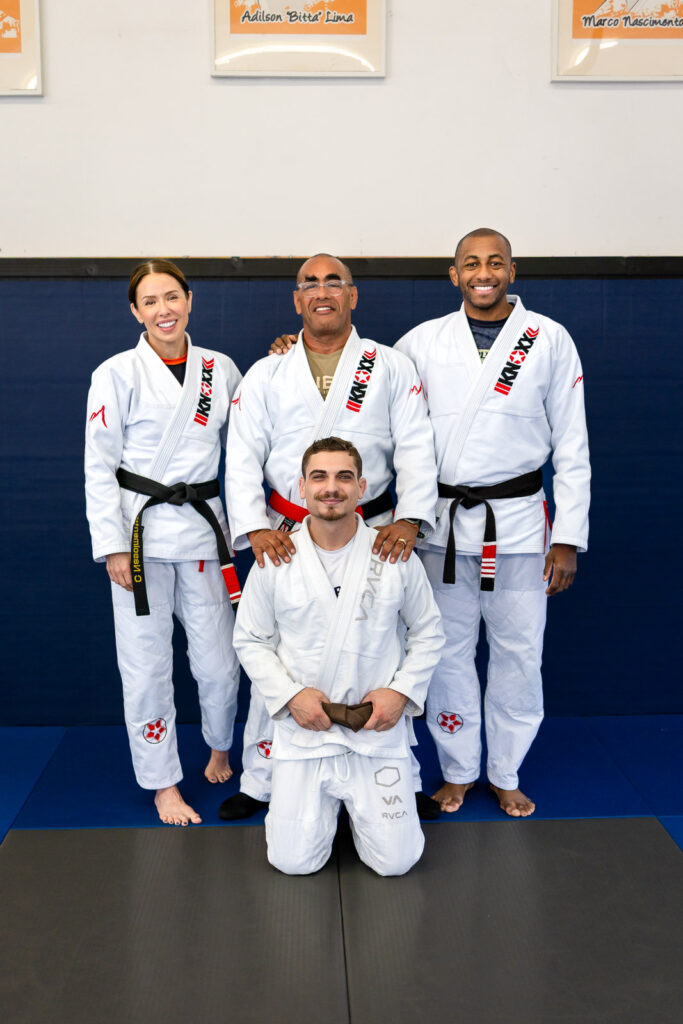 Newly promoted brown belt posing with coaches at Marco Nascimento Brazilian jiu jitsu
