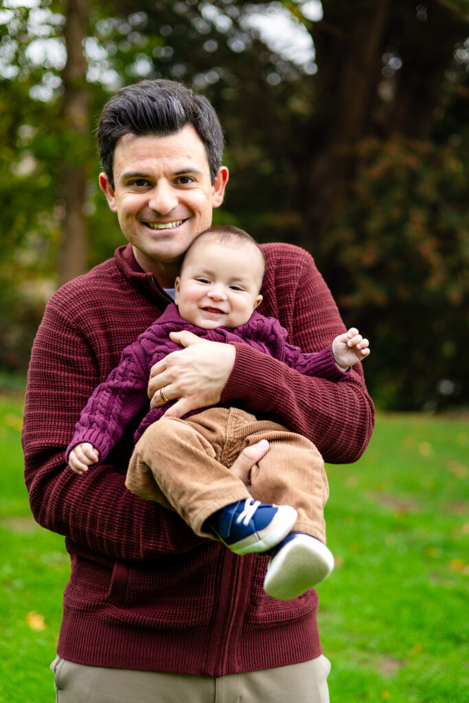 Smiling baby in dad’s arms during a family session at Millbrae Meadows