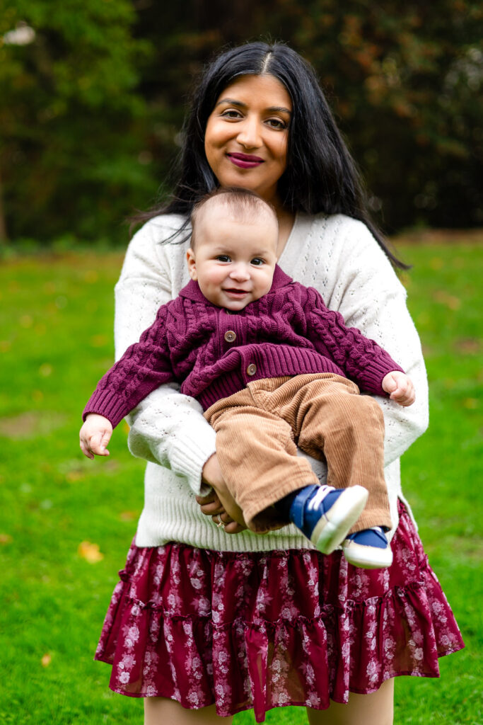Smiling baby in mom’s arms during a family session at Millbrae Meadows Park