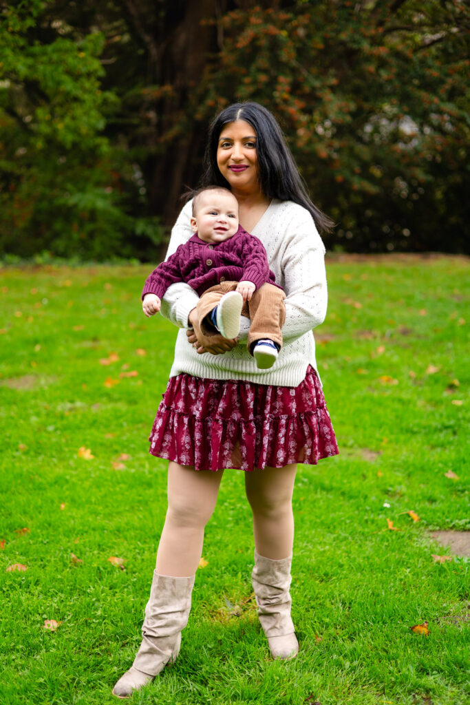 Mom standing with her baby on the grass at Meadows Park Millbrae in San Mateo County