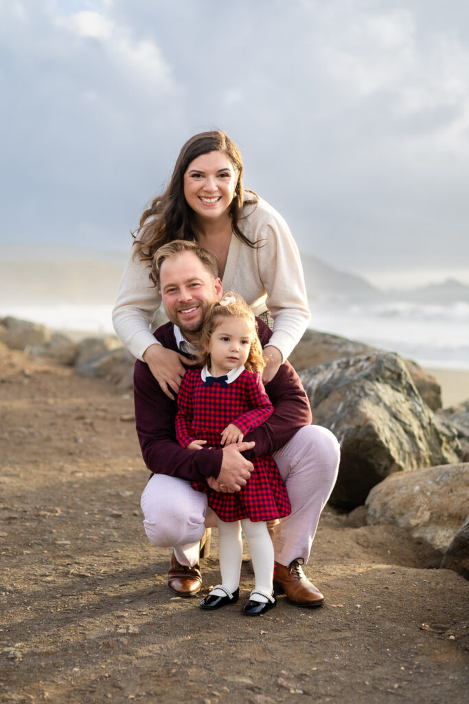Family posing together on the Pacifica shoreline for a San Mateo parent community photoshoot