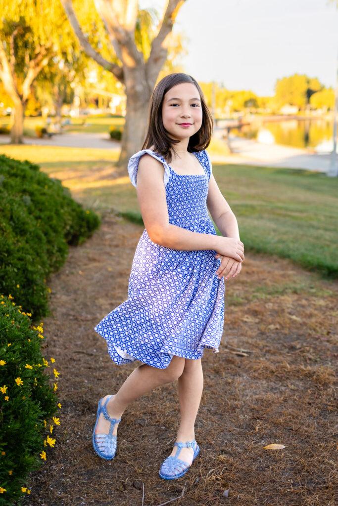 Young girl twirling in a blue dress for pictures