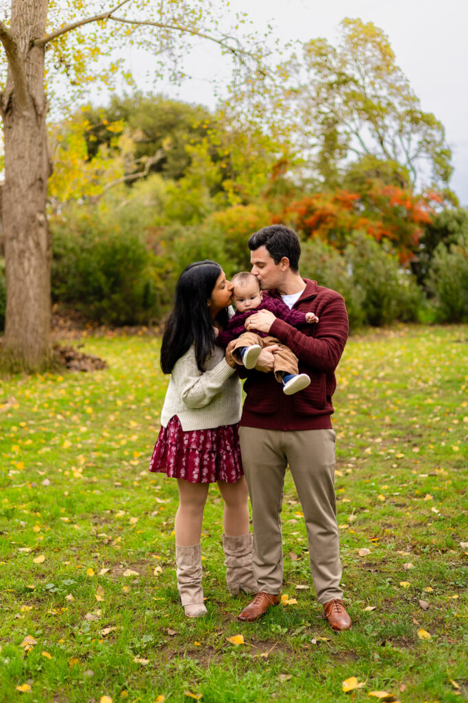 Parents kissing their baby during a Millbrae Meadows family session