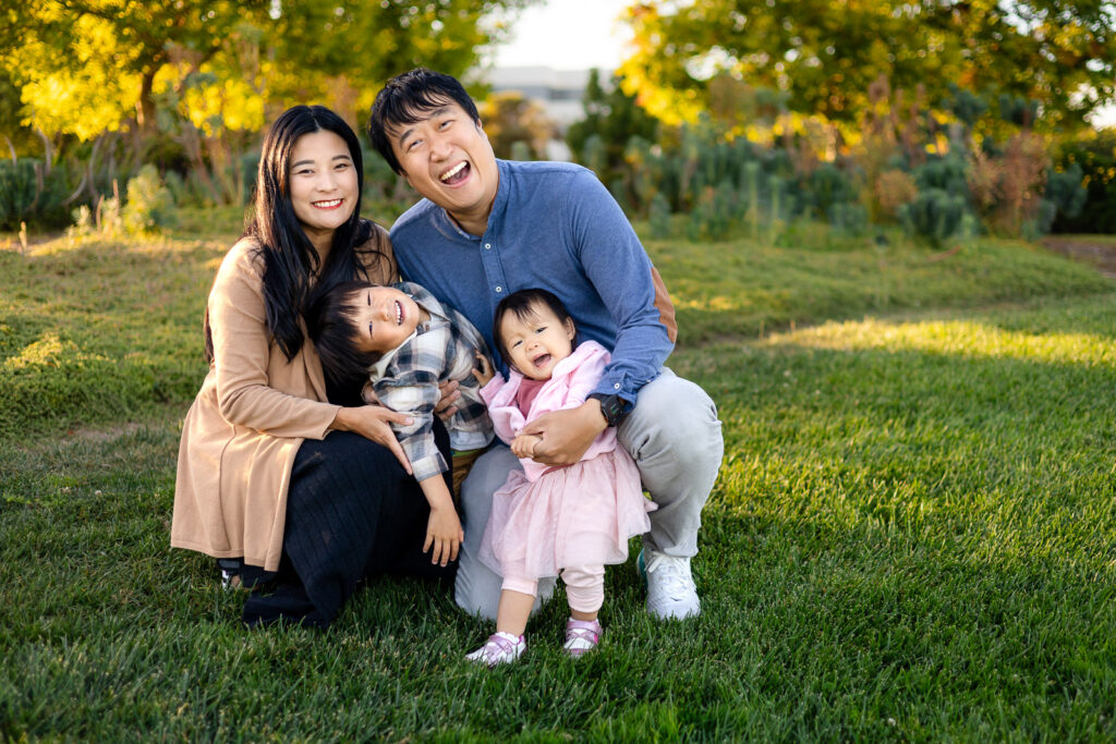Parents playing with their two young children during a joyful family session for San Mateo Parents Club
