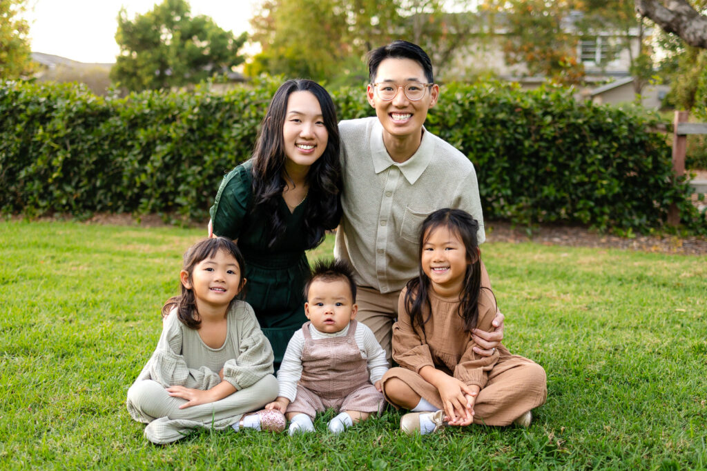 Family sitting together on the grass in a park