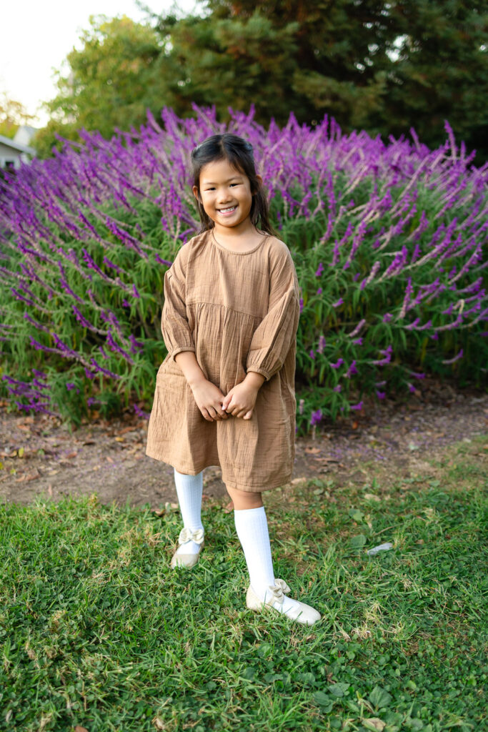 Girl standing in front of lavender flowers in a park photoshoot