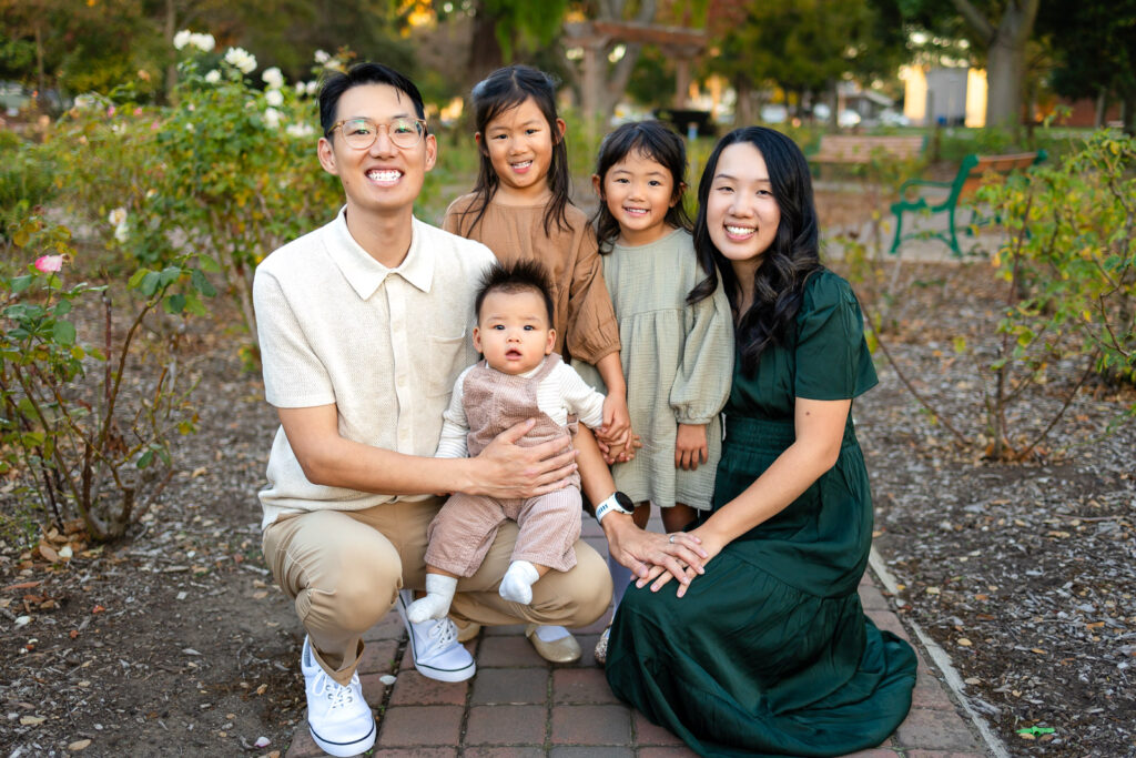 San Mateo county family with three young children smiling on a park pathway for tips for family photos with toddlers