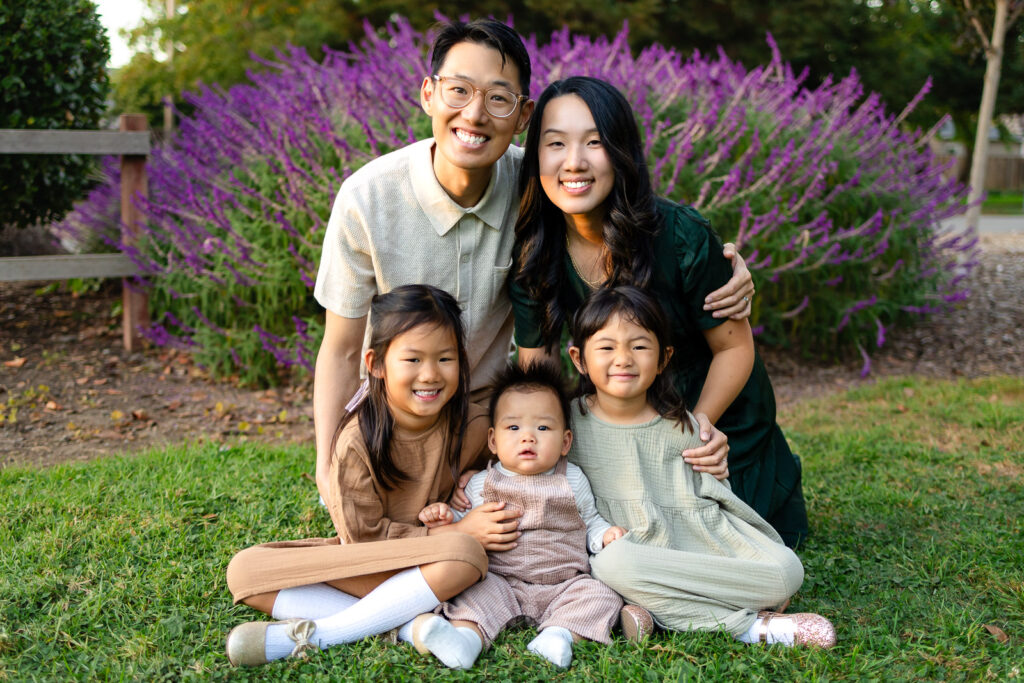 Family of five sitting together in a park for tips for family photos with children