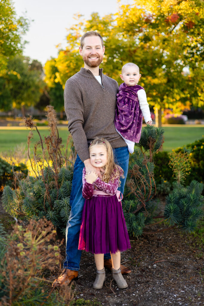 Dad standing with his two young daughters at a Foster City park for little things that make photos go well 