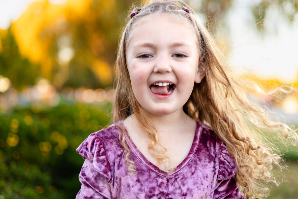 Little girl laughing in the garden path at Foster City Lagoon for a what to bring to a photoshoot feature
