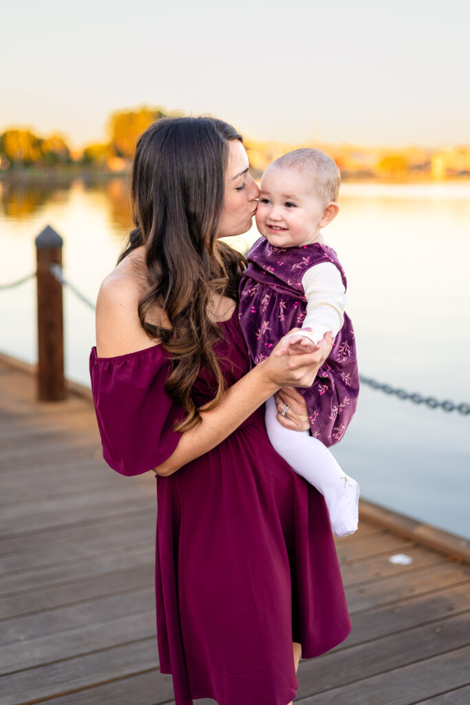 Mom kissing her baby on a wooden boardwalk at a San Mateo lake for a what to pack for a relaxed family session feature