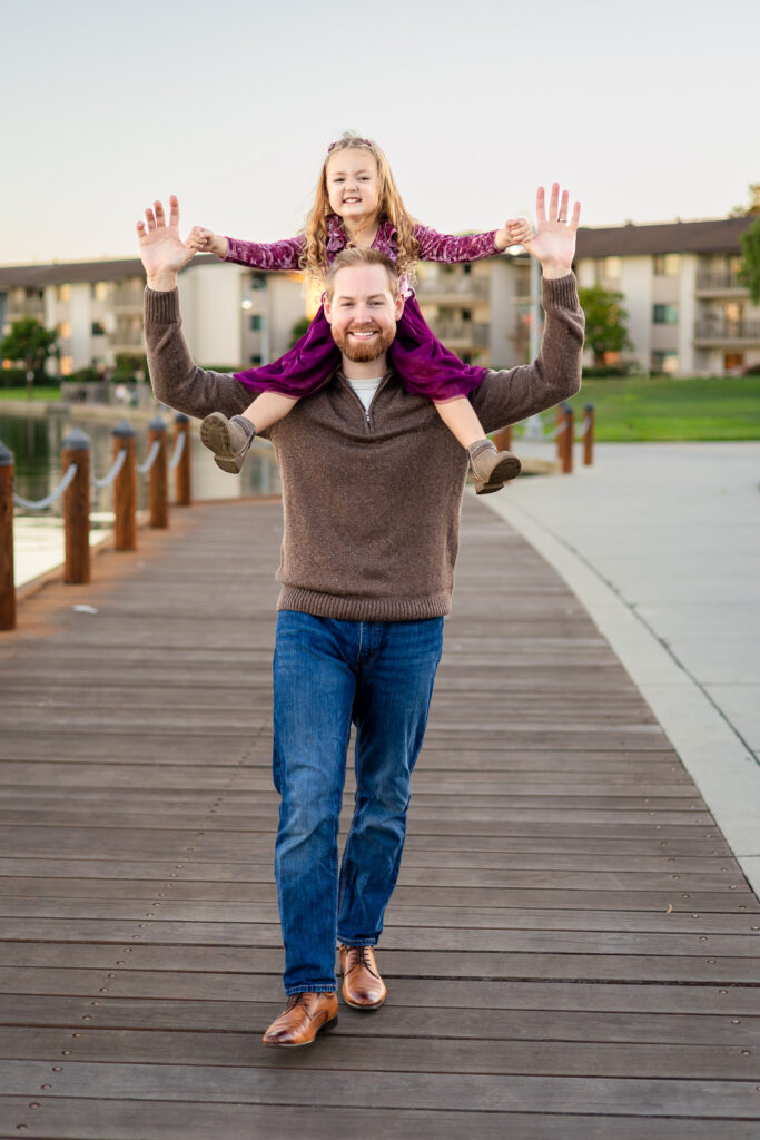 Dad walking on a boardwalk with his daughter on his shoulders at a San Mateo lake for things that make your session feel smooth article