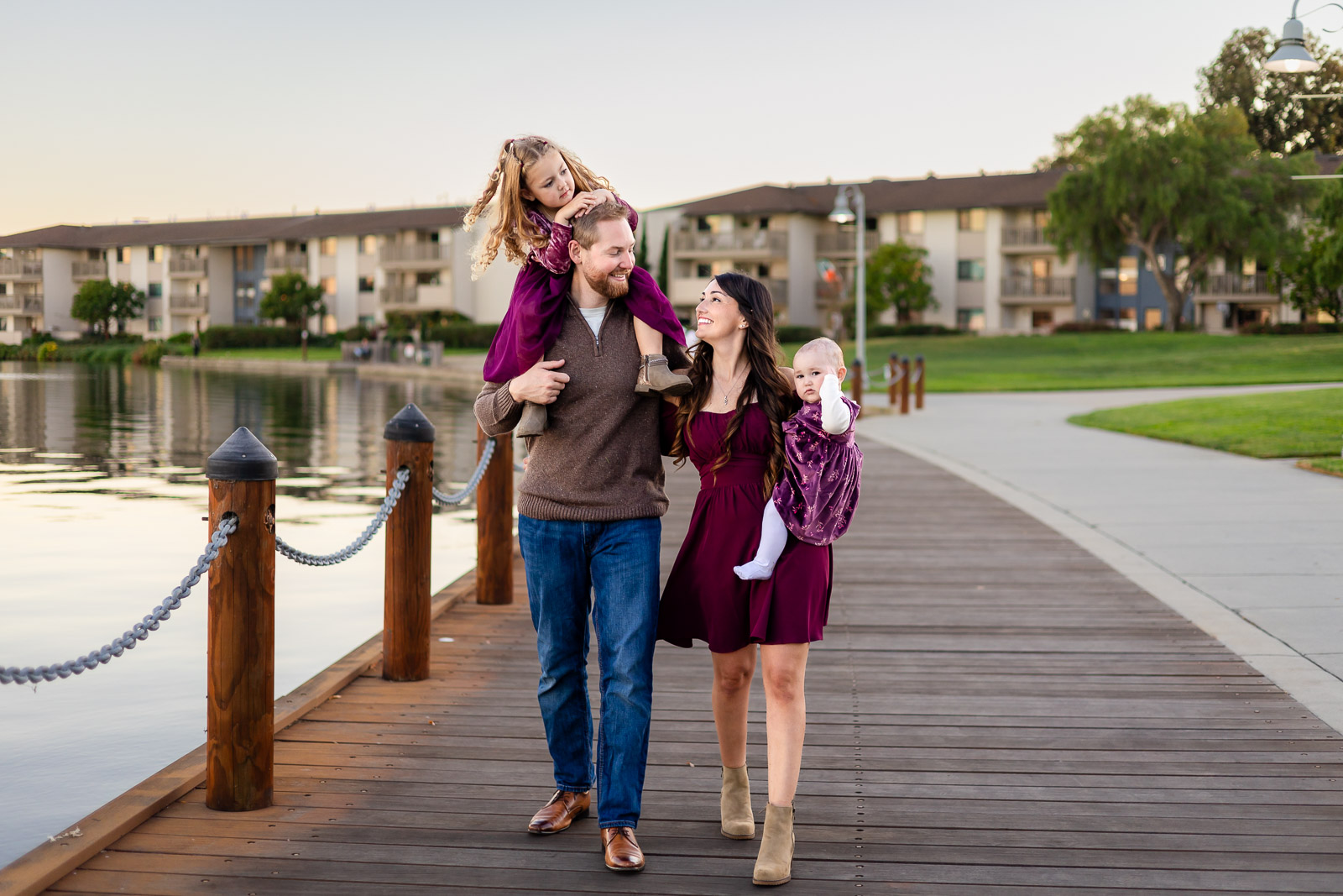 Family enjoying a walk on a lakeside boardwalk at a Foster City park for a what to bring to a photoshoot checklist. Ellobelle Photography