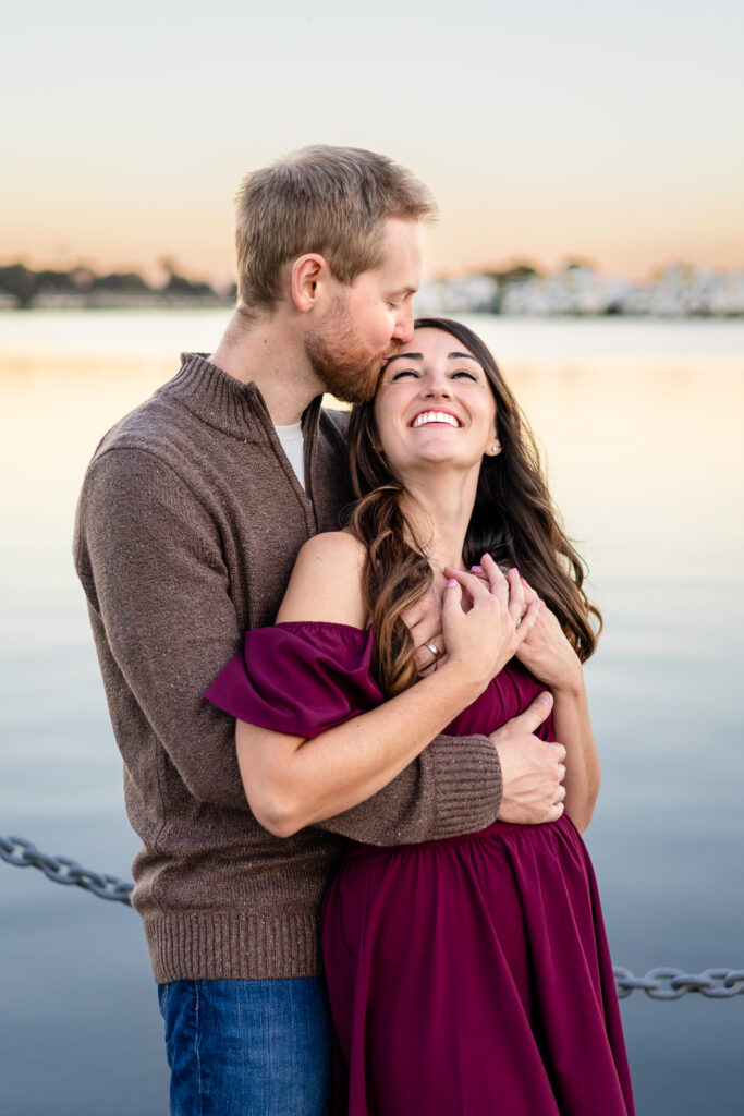 Couple sharing a sweet moment on a wooden boardwalk at a San Mateo lake for a what to pack for a photoshoot guide