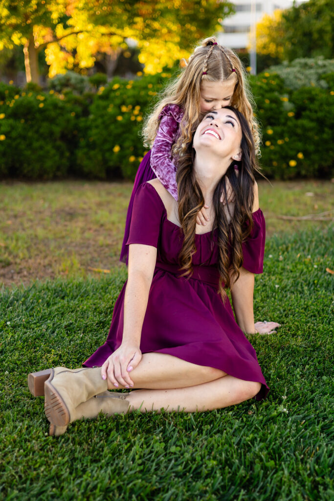 Mom and daughter laughing together on the grass at a Foster City park for your photoshoot checklist