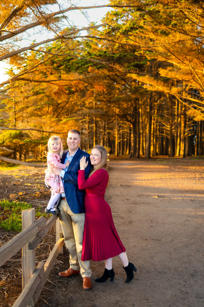 A father holds his daughter close as they smile toward the camera, photographed by a Bay Area photographer serving Half Moon Bay.