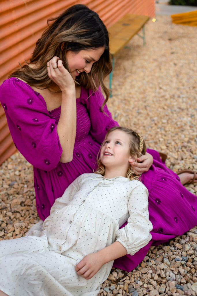 Mother sitting with daughter looking up at her during Palo Alto motherhood photos outdoor lifestyle session
