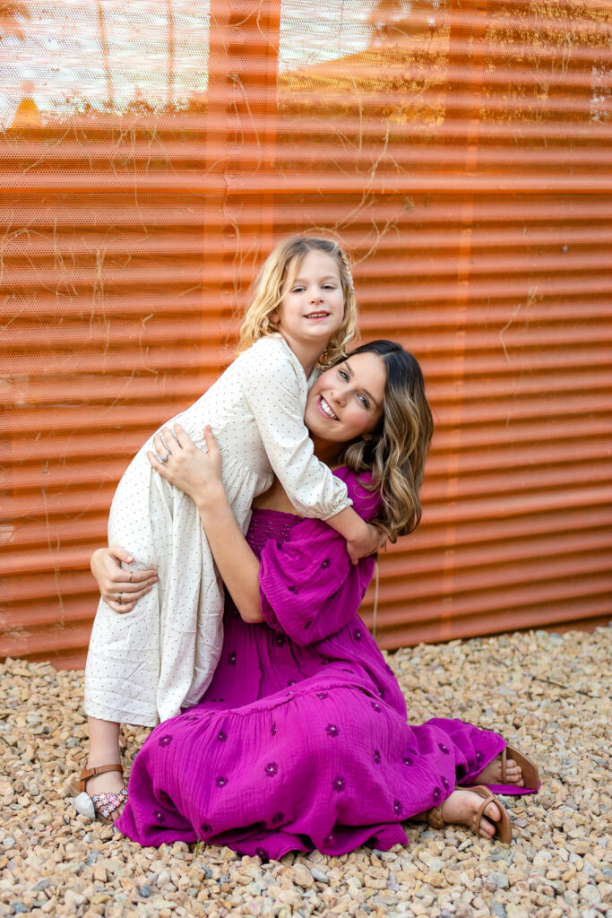 Mother lifting daughter in a joyful embrace during Motherhood mini sessions Peninsula colorful outdoor mommy and me portrait