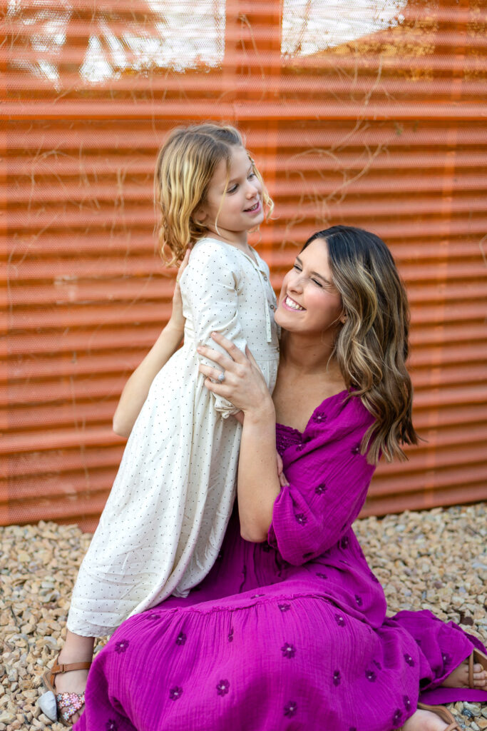 Mother laughing while lifting daughter during Palo Alto motherhood photos playful spring portrait session