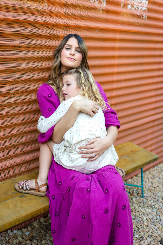 Daughter holding mother’s face while they smile at each other during Burlingame mommy and me photographer lifestyle portrait