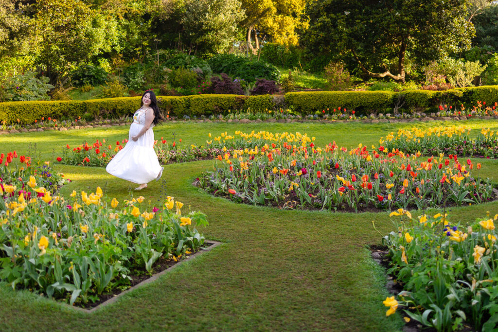 A wide landscape view of a family standing among thousands of red and yellow tulips at the Queen Wilhelmina Garden during peak spring bloom.