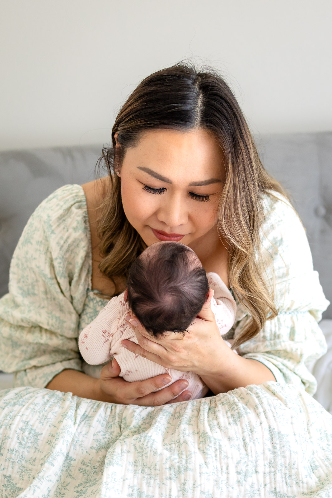 A mother gently kissing her baby’s head during a guided lifestyle session on the SF Peninsula, capturing emotional and true-to-life moments.