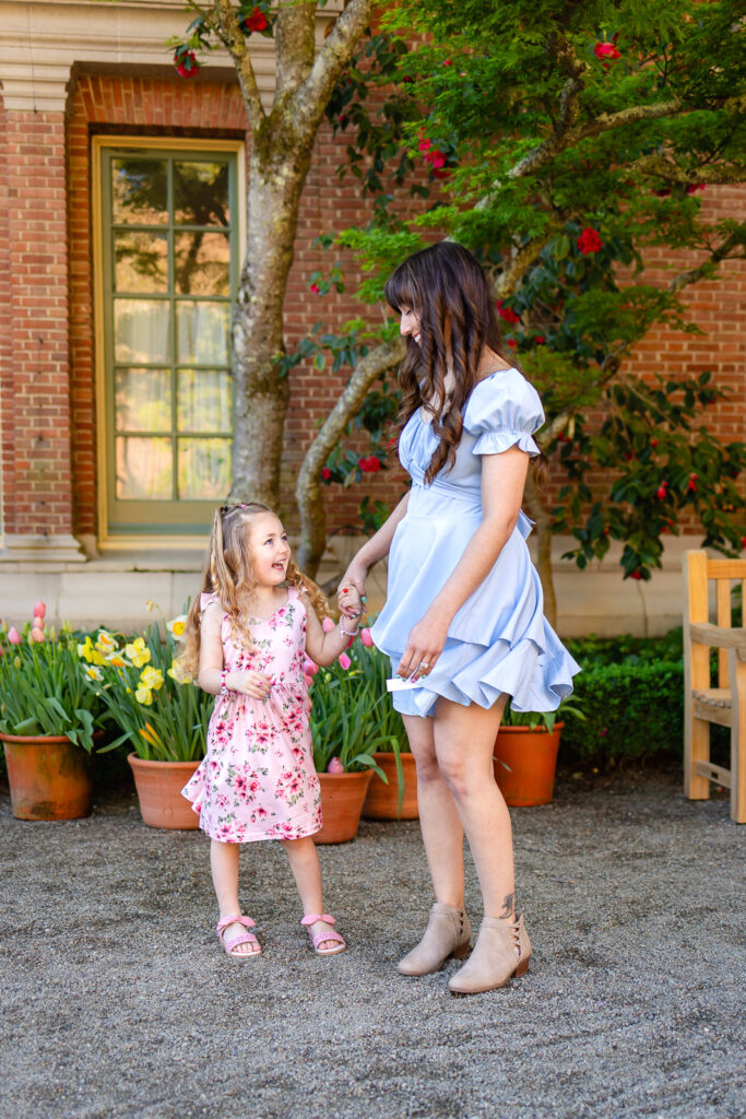 A family of four posing in front of the historic brick architecture and lush greenery at Filoli Gardens in Woodside.