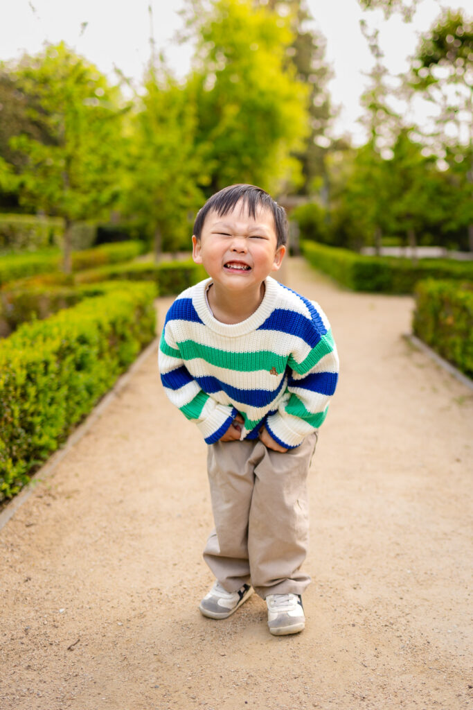 A joyful toddler walking down a manicured garden path, showing the effortless results of a session focused on real personality.