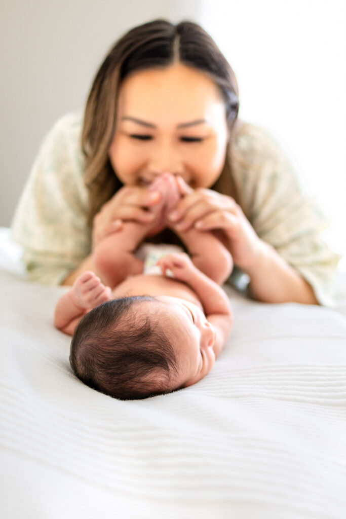 A first-time father, mother, toddler, and newborn baby posing together on a soft rug, showcasing a stress-free and connection-filled photography experience on the San Francisco Peninsula.