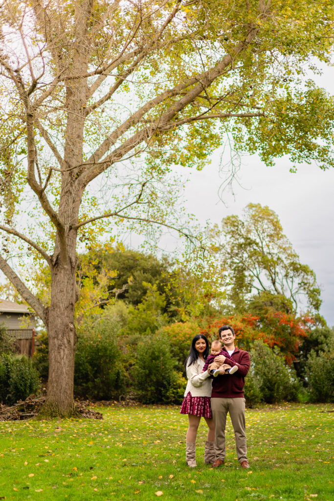 A family walking through a golden grassy field during their fall mini session.