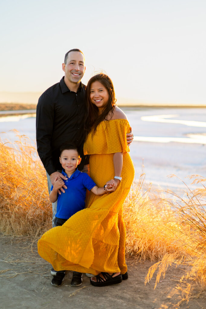 Family of three standing together during golden hour at a Bay Area family photography session