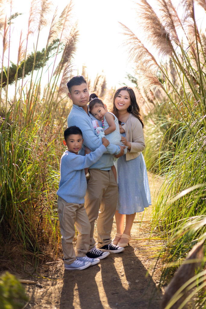 Family standing together in a golden pampas grass field near Pacifica