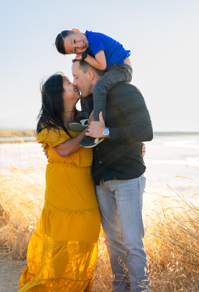 Family wearing mustard yellow, black, and blue outfits at sunset
