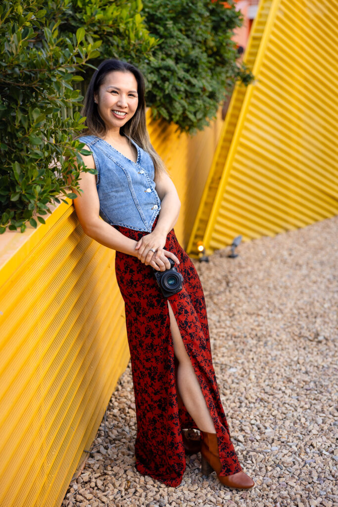 Ellen Lai holding a camera and smiling during a branding portrait session