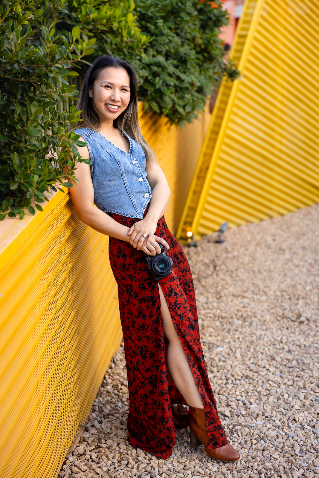 Ellen Lai holding a camera and smiling during a branding portrait session